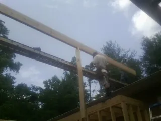 Carpenter setting a ridge beam over a new addition frame — Ice Dam Removal by Roofing Brothers in Hermiston