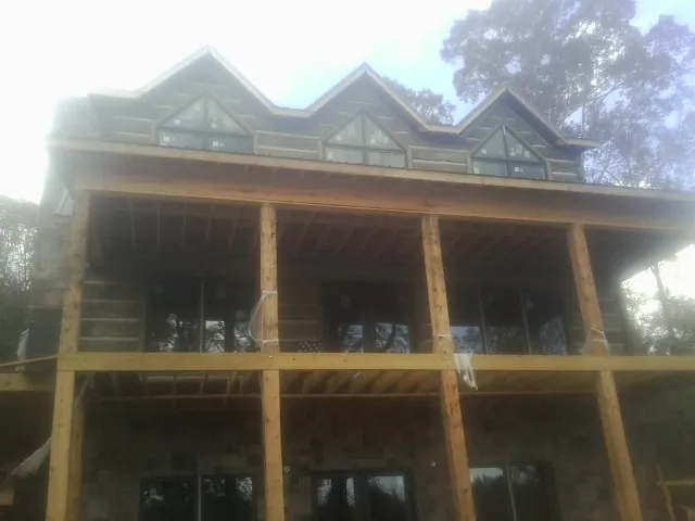 Dormers and porch framing on a large log home under construction — Roof Coating work by our crew in Hermiston